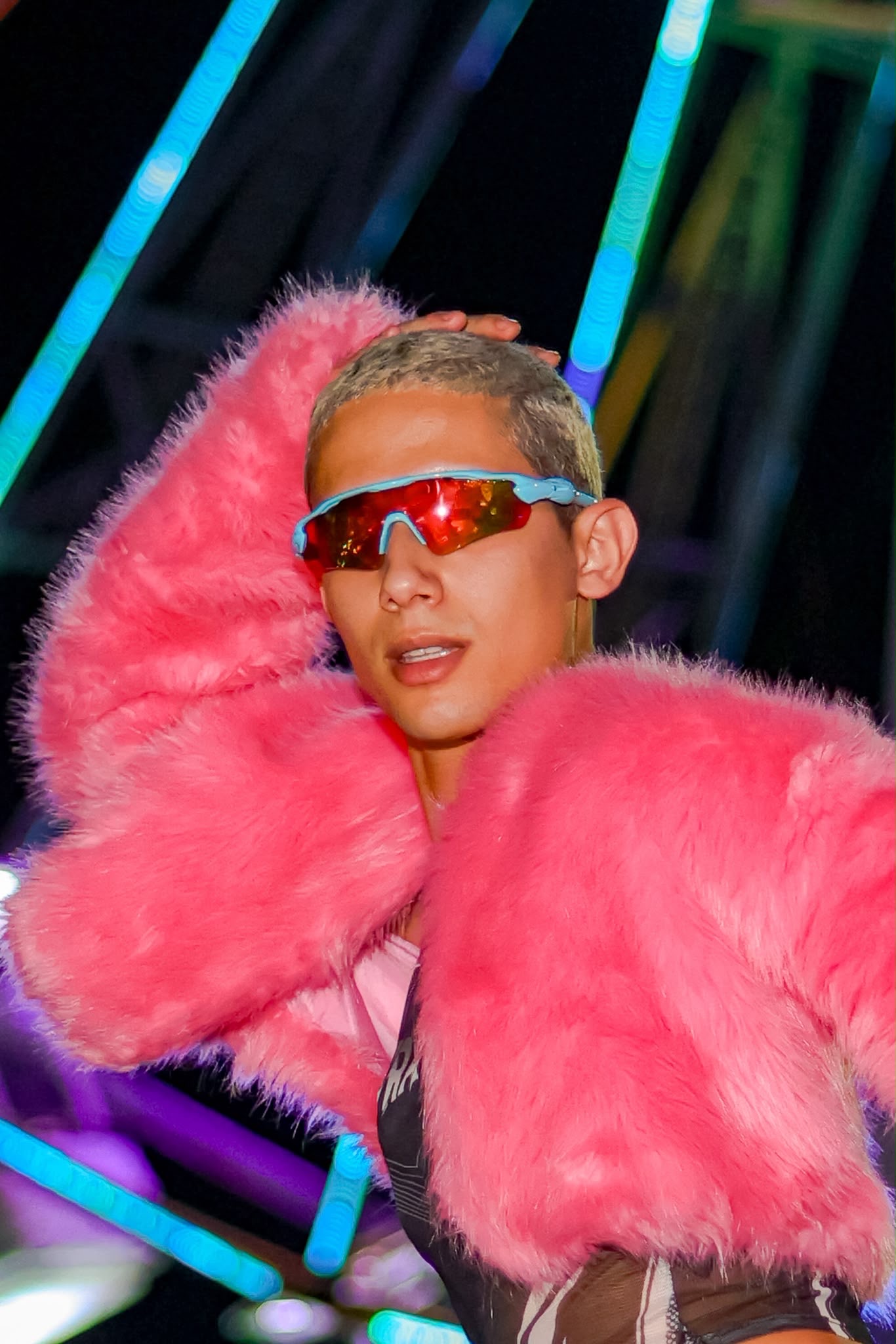 Karim Acolina wearing a hot-pink faux-fur coat and mirrored sunglasses.